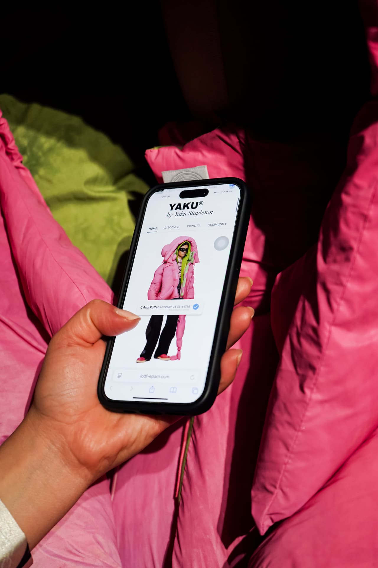 Hand holding a phone showing the YAKU connected product experience